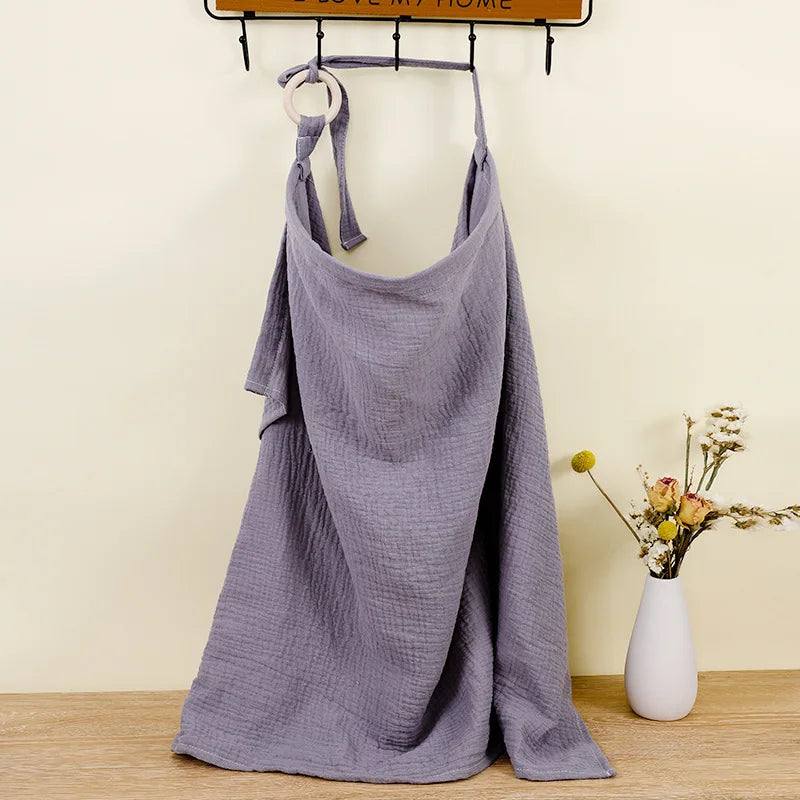 Purple dress hanging on a rack with a vase of flowers on a wooden surface.