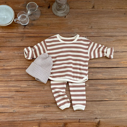 Striped baby outfit with hat on a wooden surface