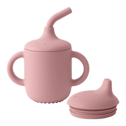 Pink sippy cup with straw and additional lid on a white background
