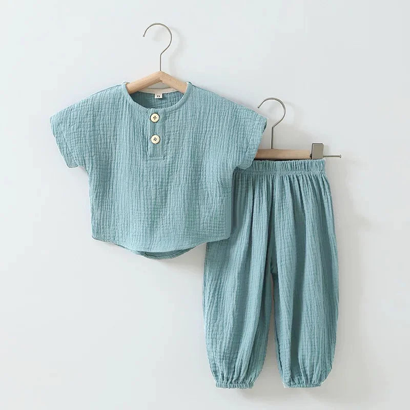 Children's blue outfit with top and pants on hangers against a white background