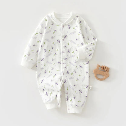 Baby onesie with floral pattern and wooden teether on a white background